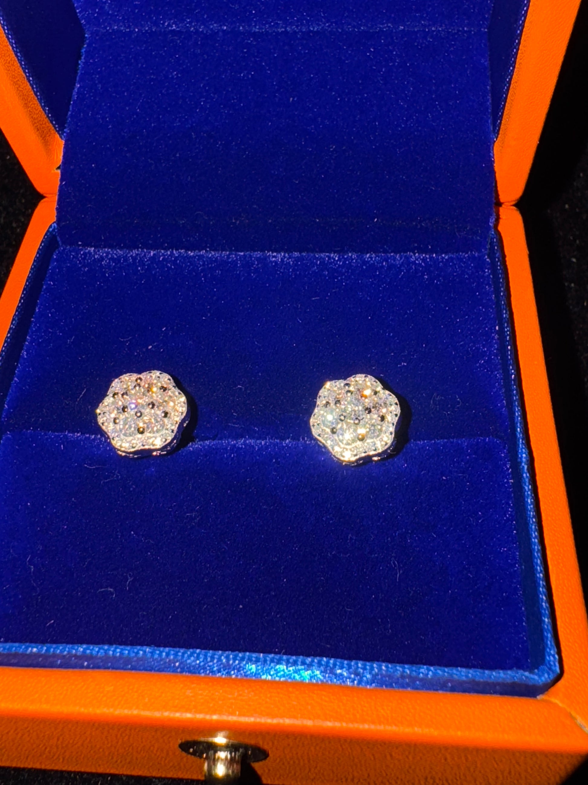 Pair of diamond earrings in an orange and blue jewelry box